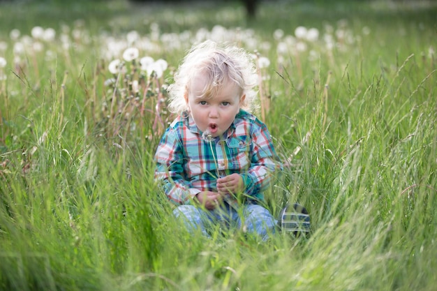Un bambino di un anno è seduto nell'erba