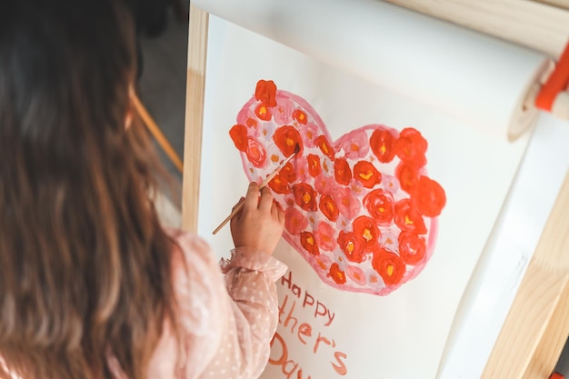 Un bambino disegna un cuore per la mamma per la festa della mamma