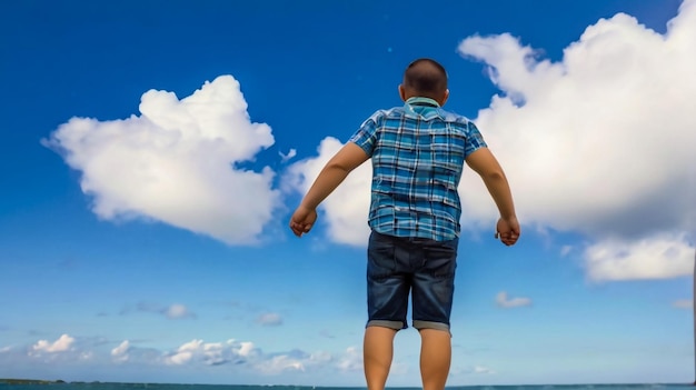 un bambino è in piedi sulla spiaggia e ha le braccia allungate