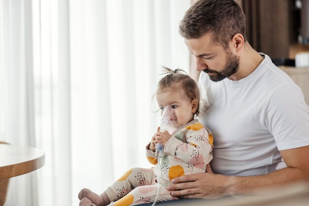 Un bambino è seduto in grembo al padre e si inspira