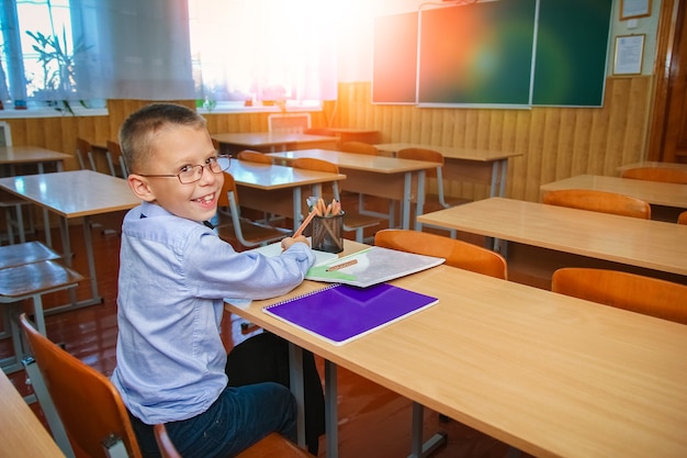 Un bambino felice al banco di scuola a scuola dopo la scuola