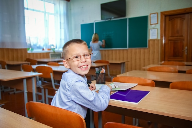 Un bambino felice al banco di scuola a scuola dopo la scuola