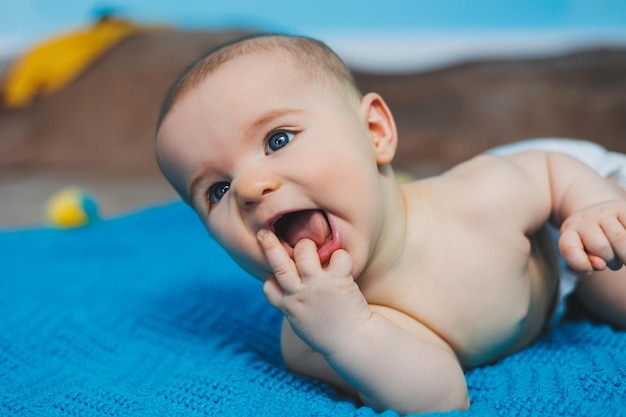 Un bambino felice di quattro mesi si trova su una coperta lavorata a maglia Ritratto di bambino bambino tenendo la testa