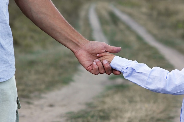 Un bambino felice e le mani dei genitori sulla natura nel viaggio del parco