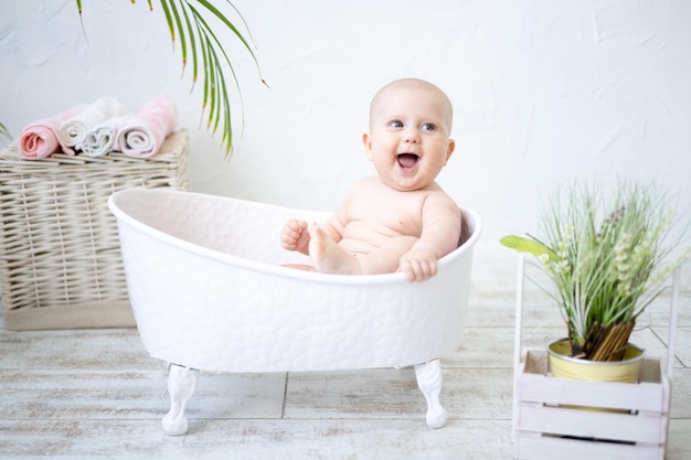 Un bambino felice felice è sdraiato in un bagno di balneazione sorridente guardando la telecamera