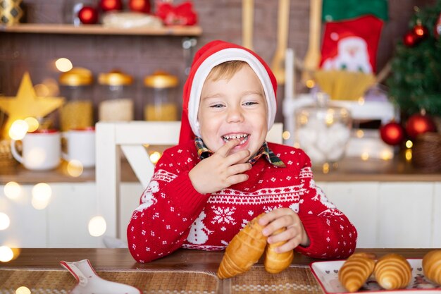 Un bambino felice festeggia il natale in cucina a casa buon natale e felice anno nuovo