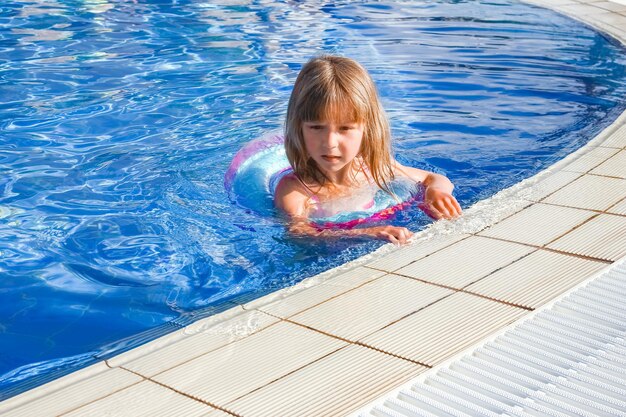 Un bambino felice gioca in piscina in riva al mare