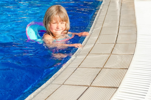 Un bambino felice gioca in piscina in riva al mare