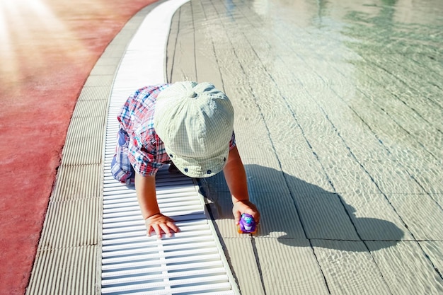Un bambino felice gioca in piscina sulla natura in riva al mare