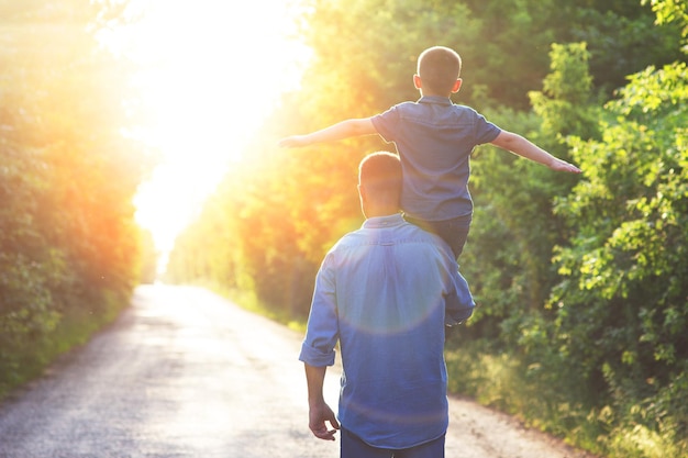 Un bambino felice sulle spalle di un genitore in natura durante il viaggio