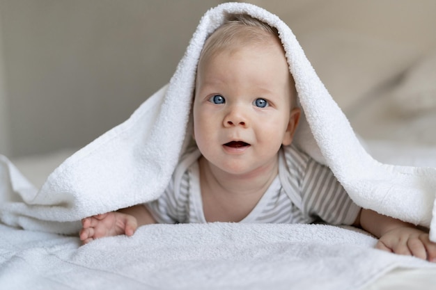 Un bambino giace sul letto, un asciugamano in testa. Concetto di bambini sani. Copia spazio