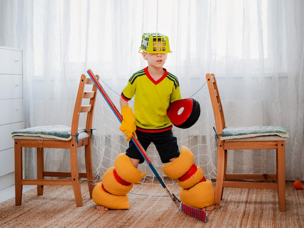 Un bambino gioca a hockey a casa