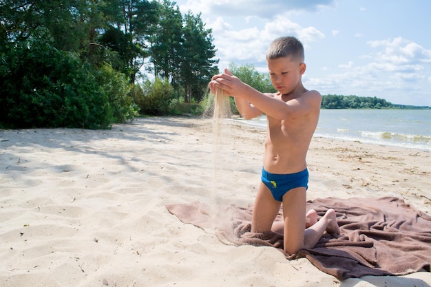 Un bambino gioca nella sabbia sulla spiaggia.