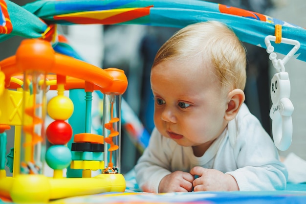 Un bambino gioca su un tappetino per lo sviluppo per due mesi Tappetino giocattolo per bambini piccoli