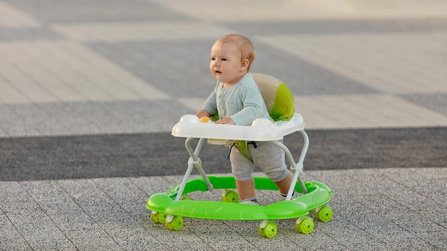 Un bambino impara a camminare su un deambulatore all'aperto