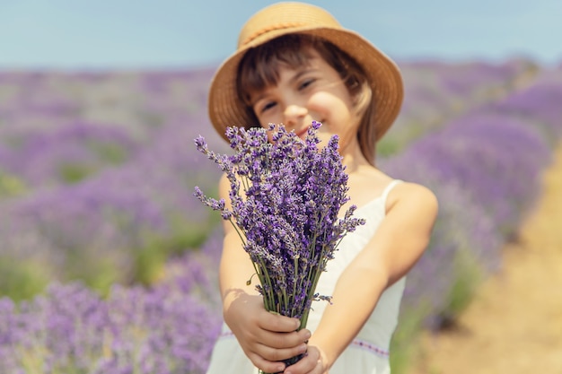 Un bambino in un campo di fioritura di lavanda.