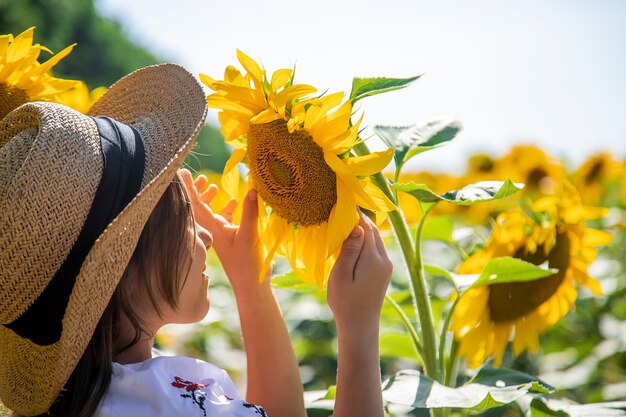 Un bambino in un campo di girasoli con una camicia ricamata. Concetto di festa dell'indipendenza dell'Ucraina. Messa a fuoco selettiva.