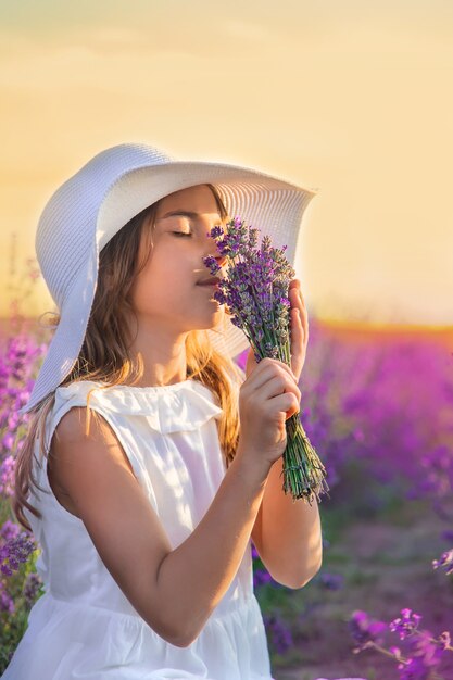 Un bambino in un campo di lavanda. Messa a fuoco selettiva.