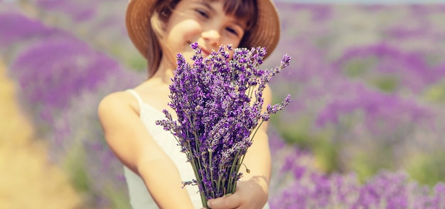 Un bambino in un campo fiorito di lavanda.