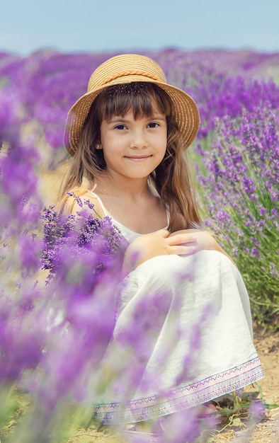 Un bambino in un campo fiorito di lavanda.