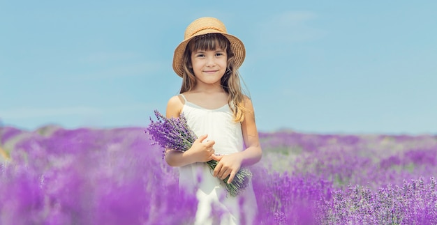 Un bambino in un campo fiorito di lavanda.