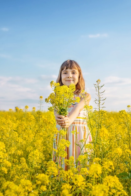 Un bambino in un campo giallo, fiori di senape