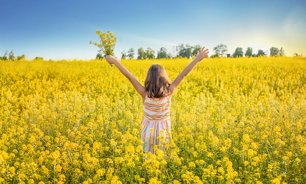 Un bambino in un campo giallo, fiori di senape