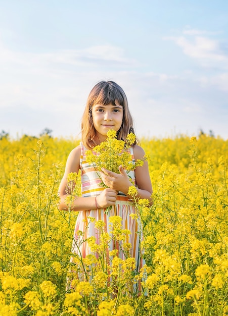 Un bambino in un campo giallo, fiori di senape