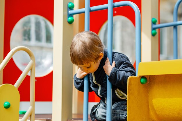 Un bambino in un parco giochi sta cavalcando su una collina divertendosi con i giochi del bambino