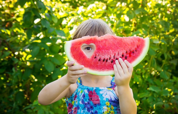 Un bambino mangia anguria. Messa a fuoco selettiva Cibo