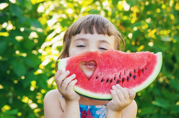 Un bambino mangia anguria. Messa a fuoco selettiva Cibo