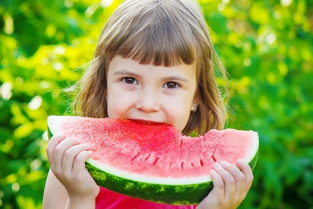 Un bambino mangia anguria. Messa a fuoco selettiva Cibo