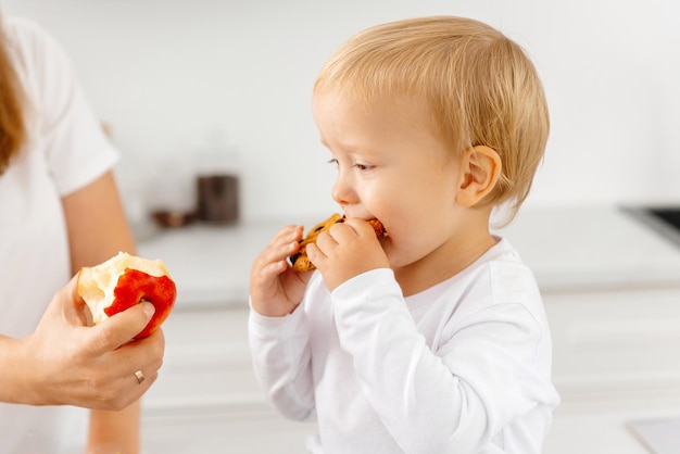 Un bambino mangia i biscotti e si rifiuta di mangiare bene e di mangiare un sano cibo riduzionista che si gode il cibo vegetale