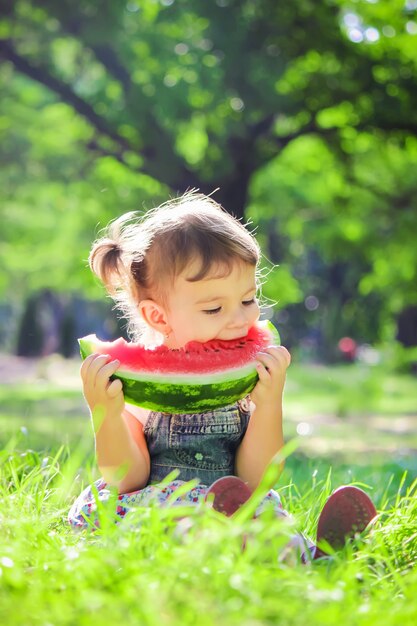 Un bambino mangia l&#39;anguria. Messa a fuoco selettiva