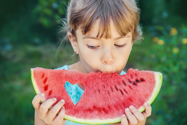 Un bambino mangia l&#39;anguria.