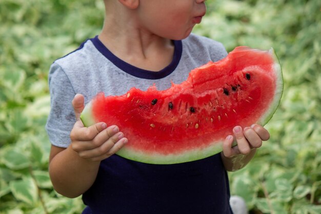 Un bambino mangia un cocomero Fuoco selettivo