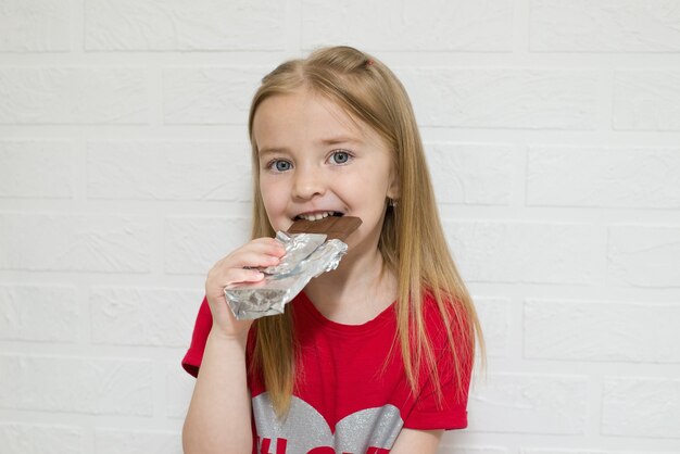 un bambino mangia un'intera tavoletta di cioccolato con un sorriso sul volto