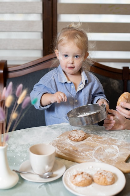 Un bambino nella farina in cucina.