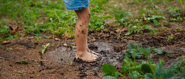 un bambino nella terra nel giardino tiene la terra nelle mani attenzione selettiva