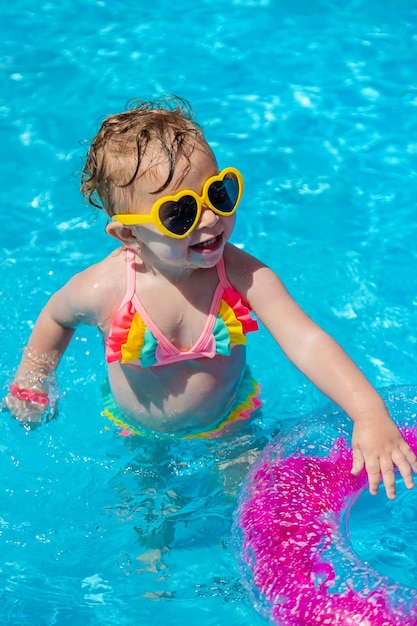 Un bambino nuota in una piscina con un cerchio Messa a fuoco selezione