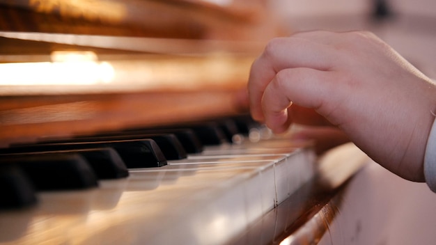 Un bambino passa a suonare il pianoforte durante una lezione di musica a scuola da vicino