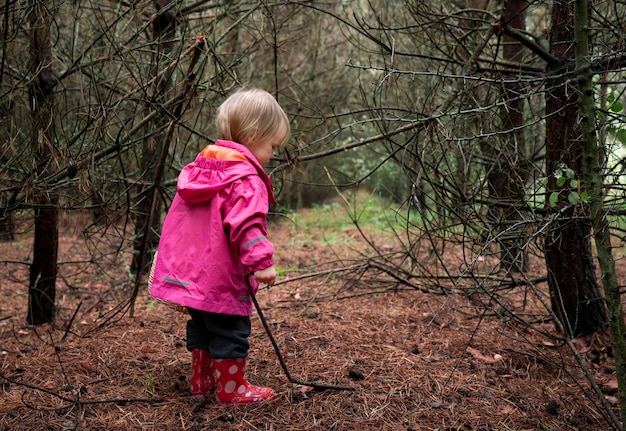 Un bambino piccolo cammina nella foresta