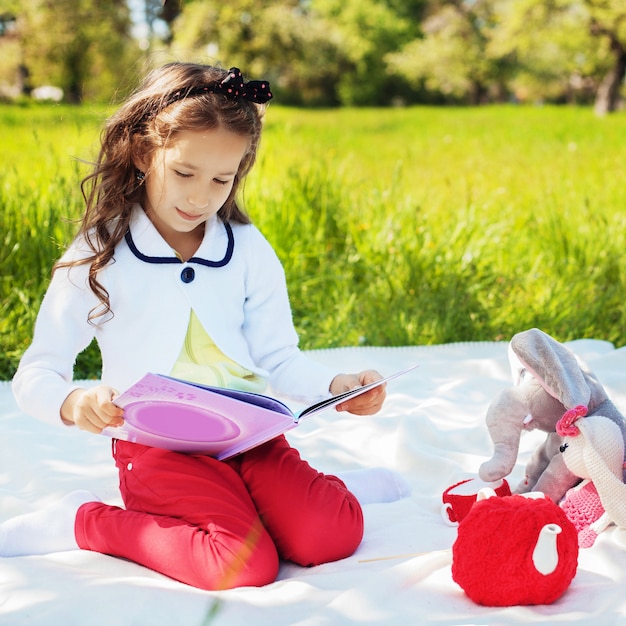 Un bambino piccolo sta leggendo un libro interessante con fiabe.