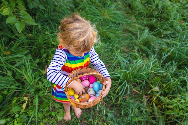 Un bambino raccoglie uova di Pasqua nell'erba Focalizzazione selettiva