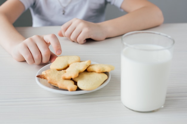 Un bambino ruba da un piatto di biscotti fatti in casa appena sfornati