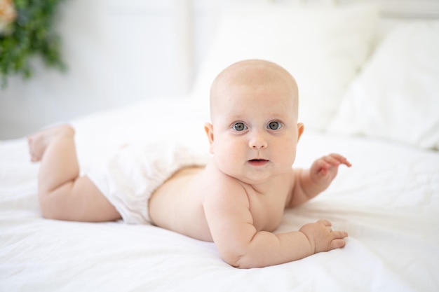 Un bambino sano e felice si trova a pancia in giù e guarda la telecamera