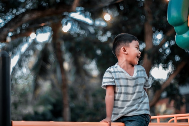 Un bambino si arrampica su una griglia alpina in un parco in un parco giochi in una calda giornata estiva parco giochi per bambini in un parco pubblico animazione e svago per bambini