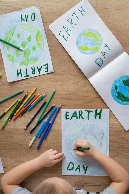 Un bambino sta disegnando la terra su un foglio.