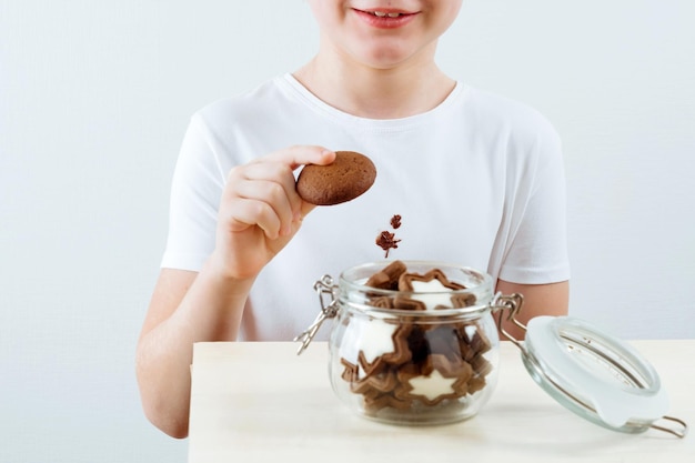 Un bambino sta mangiando un budino al cioccolato in un barattolo.