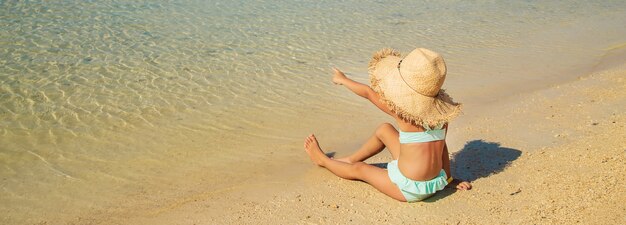 Un bambino sulla spiaggia vicino al mare.